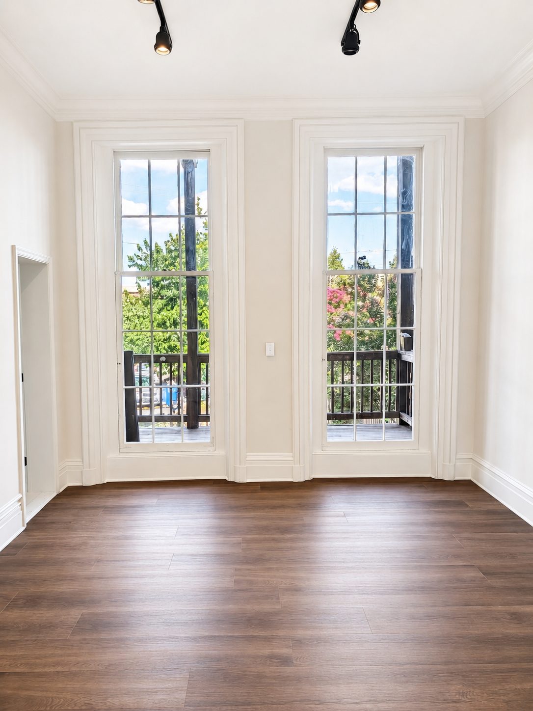 Tall twelve-pane windows opening to a private deck